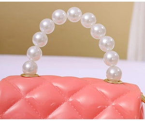 Detail of pink jelly bag with quilted texture and white faux pearl bead handle