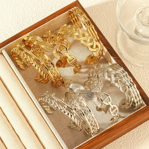 Detailed view of assorted gold and silver stainless steel bangles with diverse textures