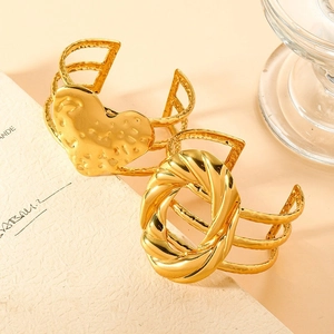 Gold plated stainless steel open bangles featuring heart and oval textured charms
