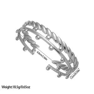 Detailed view of silver C-shaped bangle with twisted rope and bead layer design