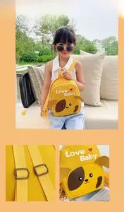 Close-up of yellow canvas schoolbag featuring a cartoon dog and adjustable straps