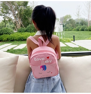 Pink canvas unicorn backpack for kids with Love Baby embroidery shown in outdoor use