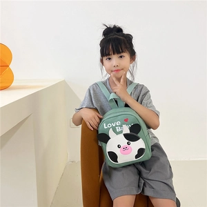 Close-up of a green canvas toddler backpack with a cute cow patch and Love Baby print