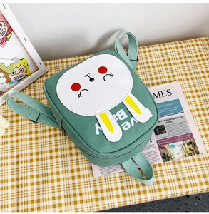 Close-up of green canvas toddler backpack featuring a 3D bunny and Love Baby text