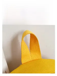 Detailed macro view of the durable yellow canvas strap and woven texture on a kids backpack