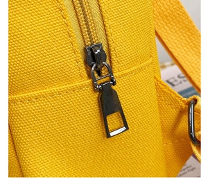 Close-up of durable yellow canvas fabric with premium metal zipper detail on children backpack