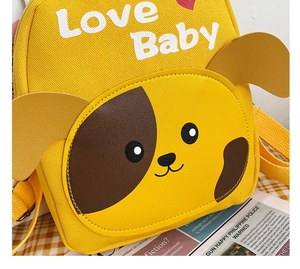 Detail of yellow toddler backpack with a 3D dog face and soft canvas shoulder straps