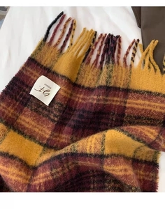 Close-up of the vintage plaid scarf fabric with long tassels and BLOSSOM brand label
