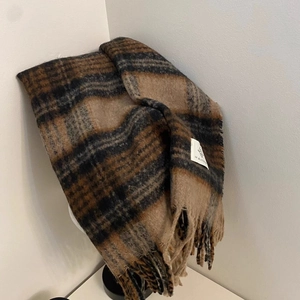 Close-up of vintage plaid scarf with tassels and stitched woven label detail