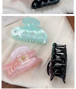 Detail of acrylic flower hair claw clips with sparkling rhinestone embellishments
