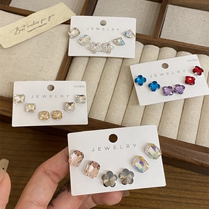 Macro shot of 925 silver needle stud earrings set with sparkling geometric gemstones