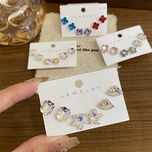 Macro shot of assorted geometric diamond stud earrings on branded jewelry display card