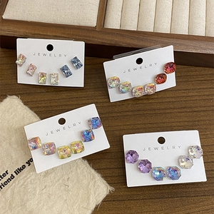 Detailed view of faceted crystal stud earrings in multiple colors on jewelry cards