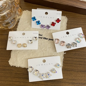 Sparkling geometric earrings set with blue, red, and champagne crystals on 925 silver studs