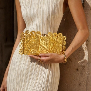 Golden acrylic evening clutch bag with geometric pleated texture and round metal trim