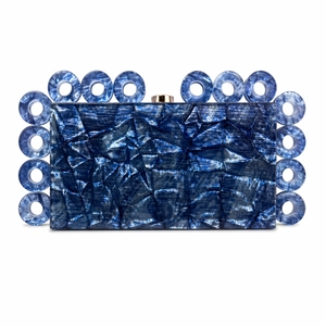 Detail view of navy blue acrylic evening clutch bag with ring accents and gold clasp
