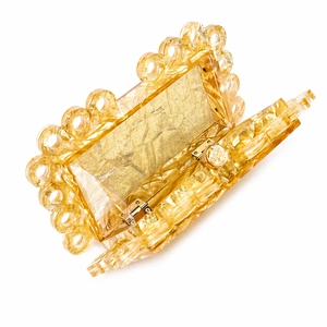 Detail view of acrylic evening clutch with amber gold finish and ring chain edge