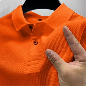 Close-up of orange polo shirt showing detailed pique cotton texture and two-button placket