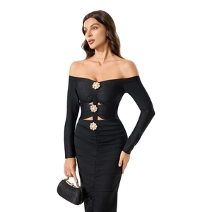 Détail de boutons en perles fleurs dorées et découpes sur une robe noire à épaules dénudées