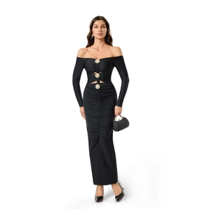 Détail de robe bandage noire à épaules dénudées avec découpes et boucles de perles dorées