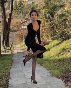 Détail d'une robe noire élégante à manches longues avec collants à pois et talons hauts
