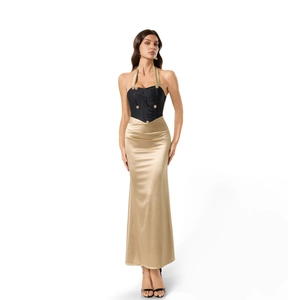 Détail de la robe licou avec haut corset noir, boutons dorés et jupe longue en satin