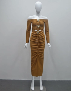 Détail d'une robe froncée moutarde avec décolleté épaules nues et boucles fleurs en strass
