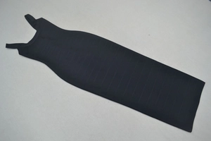 Dettaglio dell'abito aderente nero con trama a costine e spalline larghe in evidenza