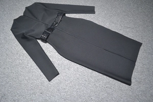 Détail d'une robe noire à manches longues avec ceinture motif croco et fente au dos