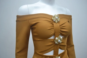 Détail des boutons en perles fleurs et de la découpe plissée sur la robe en tricot