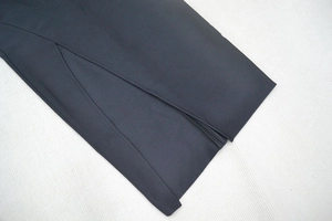 Detailed close-up showing the high side slit and precise stitching on the black bandage dress