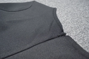 Gros plan d'une robe bandage noire montrant la fermeture éclair latérale et la texture