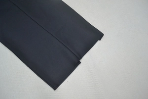 Detail shot of navy fabric texture with precise stitching and refined hem finishing