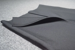 Détail du tissu côtelé noir élastique avec double couture durable sur la robe à manches longues
