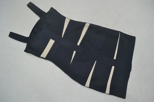 Détail de robe bandage contrastée avec rayures bicolores et fermeture éclair centrale en métal
