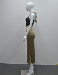 Détail montrant la texture du satin doré et la couture à la taille de la robe licou