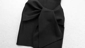 Gros plan d'une robe moulante noire avec un grand nœud décoratif et un tissu texturé détaillé