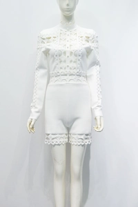 Détail d'un combishort blanc à manches longues avec dentelle géométrique et boutons perles