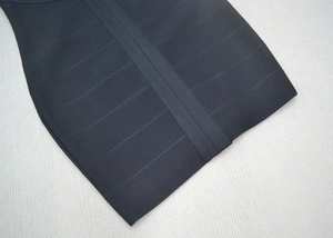 Détail d'une robe bandage noire montrant le tissu élastique à texture côtelée premium