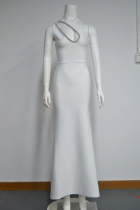 Détail d'une robe de soirée blanche à une épaule avec des chaînes élégantes en strass argentés