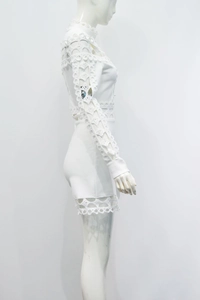 Détail d'une combinaison en dentelle blanche avec crochet floral et broderie ajourée