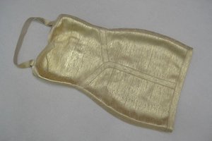 Détail de la robe bandage dorée à licou avec texture scintillante en feuille de métal