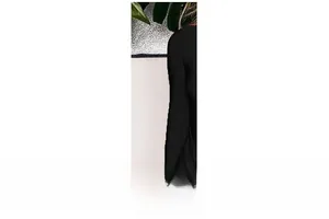 Gros plan détaillé de la manche longue ajustée sur une robe noire minimaliste pour femme