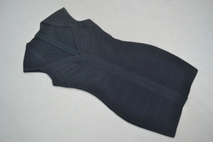 Détail d'une robe bandage noire avec col en V profond et fermeture éclair métallique