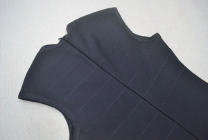 Détail de robe bandage noire avec fermeture éclair invisible dans le dos et col en V chic
