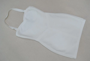 Détail d'une mini robe bandage blanche montrant les coutures texturées et le décolleté cœur