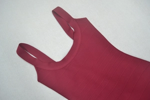 Dettaglio del tessuto bandage bordeaux che mostra la trama a coste e l'elasticità del top senza maniche