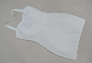 Vue détaillée de la fermeture éclair invisible et du tissu bandage blanc de la mini robe