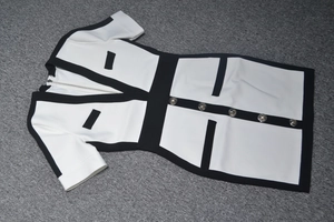 Détail de la robe bandage à col en V montrant des boutons tête de lion et bordure noire