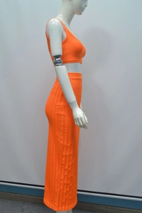 Detail eines orangefarbenen Rippstrick-Zweiteilers mit kurzem Oberteil und engem Maxirock
